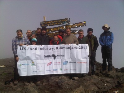 The team triumphantly unfurls its banner at Uhuru Peak at the top of Mt Kilimanjaro