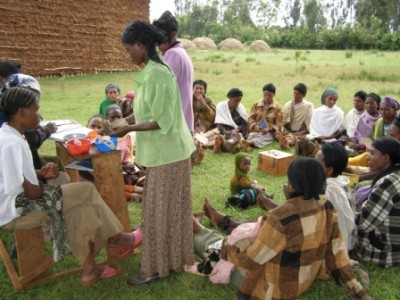 Women make contributions to shared savings at a Village Savings and Lending Association meeting