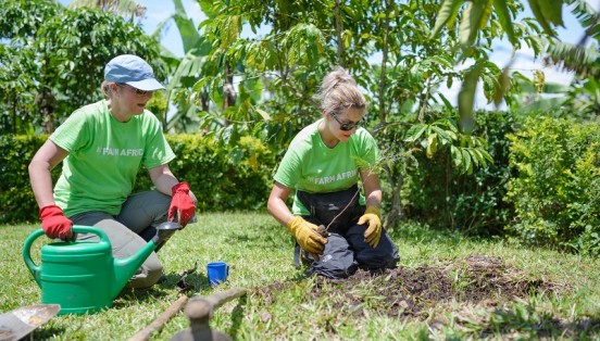 Sarah Louise Fairburn planting tree sapling in Uganda