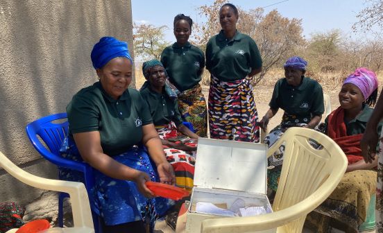 The Mwagnaza women's group sitting with their savings box