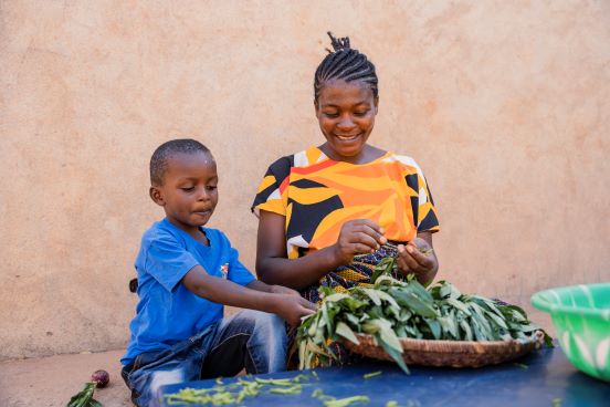 mum preparing vegetables with son Tanzania