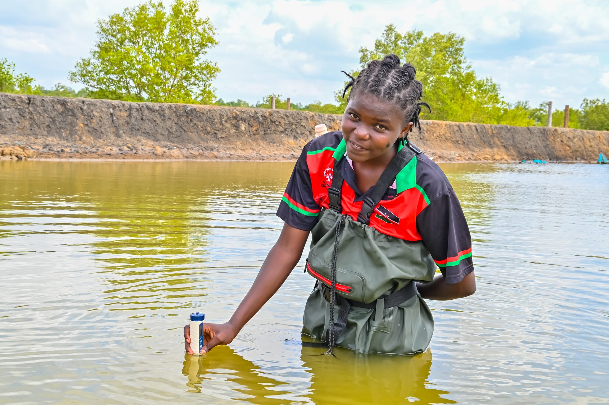 A participant in Farm Africa's Youth in Sustainable Aquaculture programme records the quality of water in a fishpond in Kilifi, Kenya.