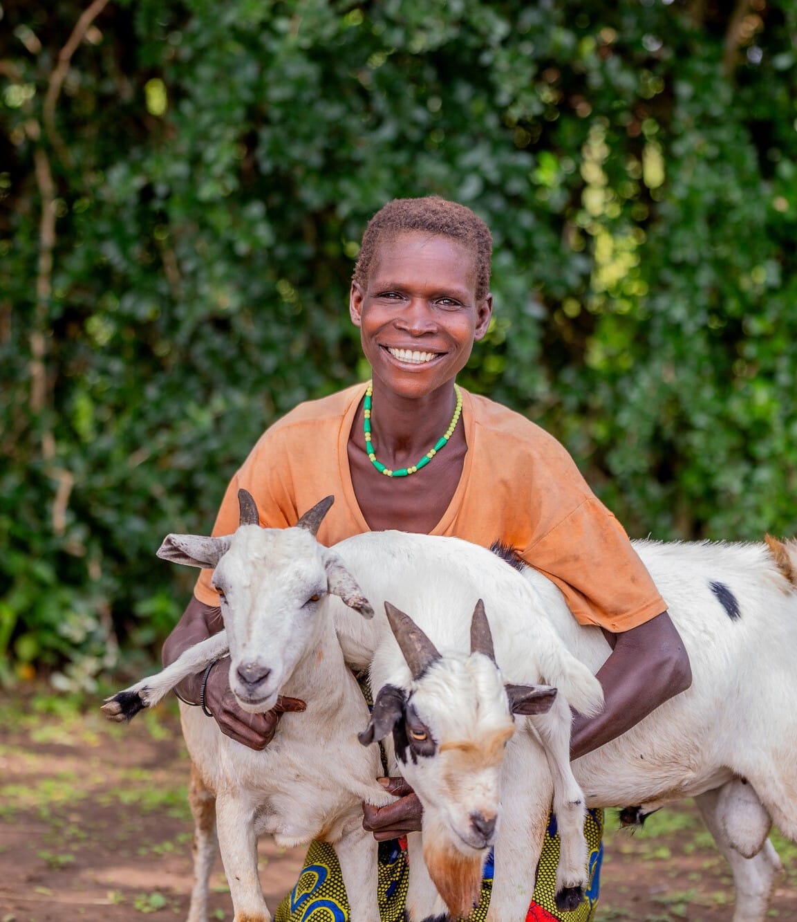 Ugandan farmer Agnes pictured with two goats.