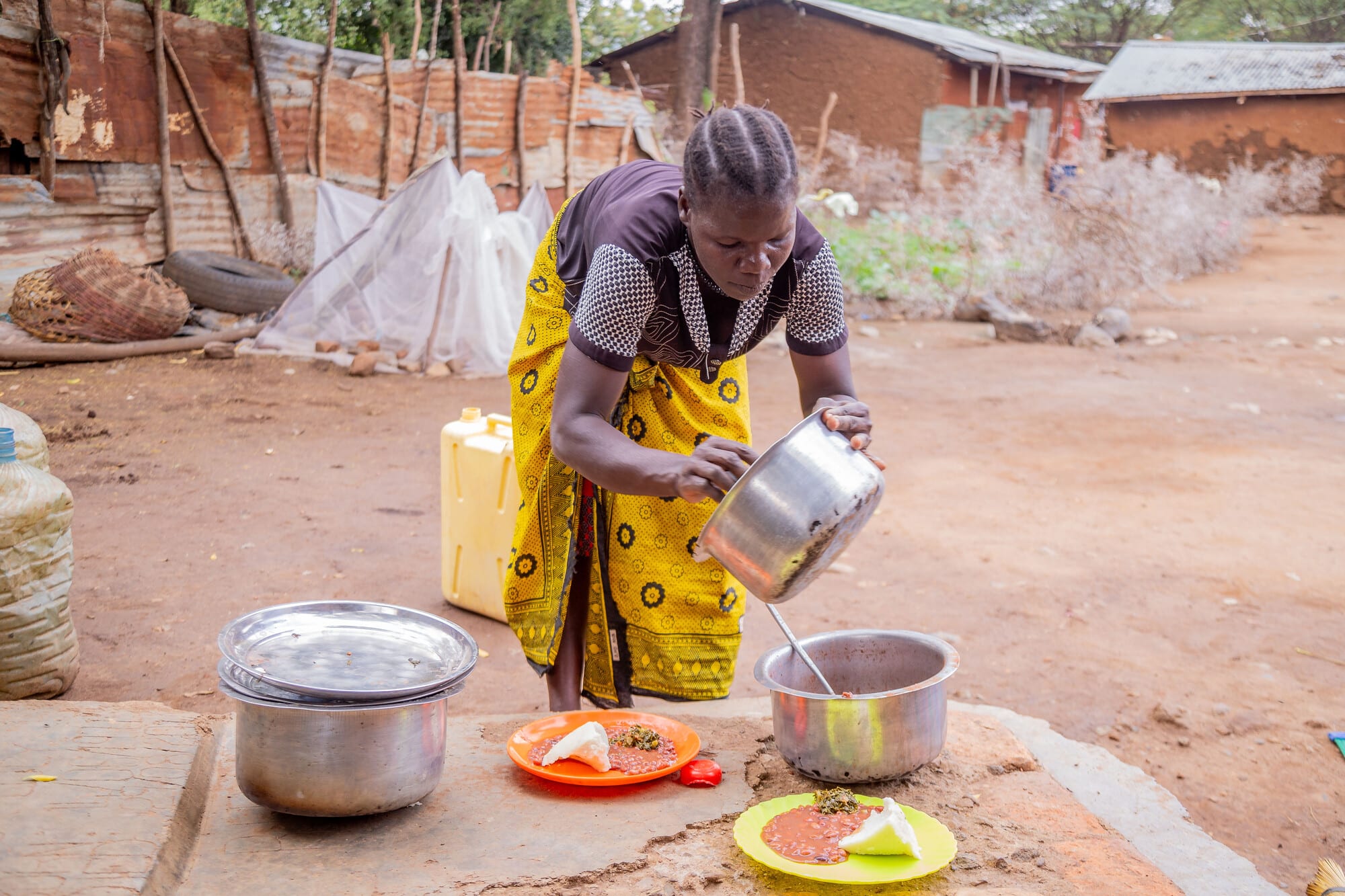Florence, 42 years old, a member of the Naukoi Riverside Farm Group in Karamoja, Uganda preparing a healthy meal for her children.