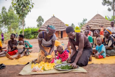 Annette and Dorcas from Karamoja in Uganda using pumpkin, cow pea leaves and groundnuts to prepare a nutritious meal.