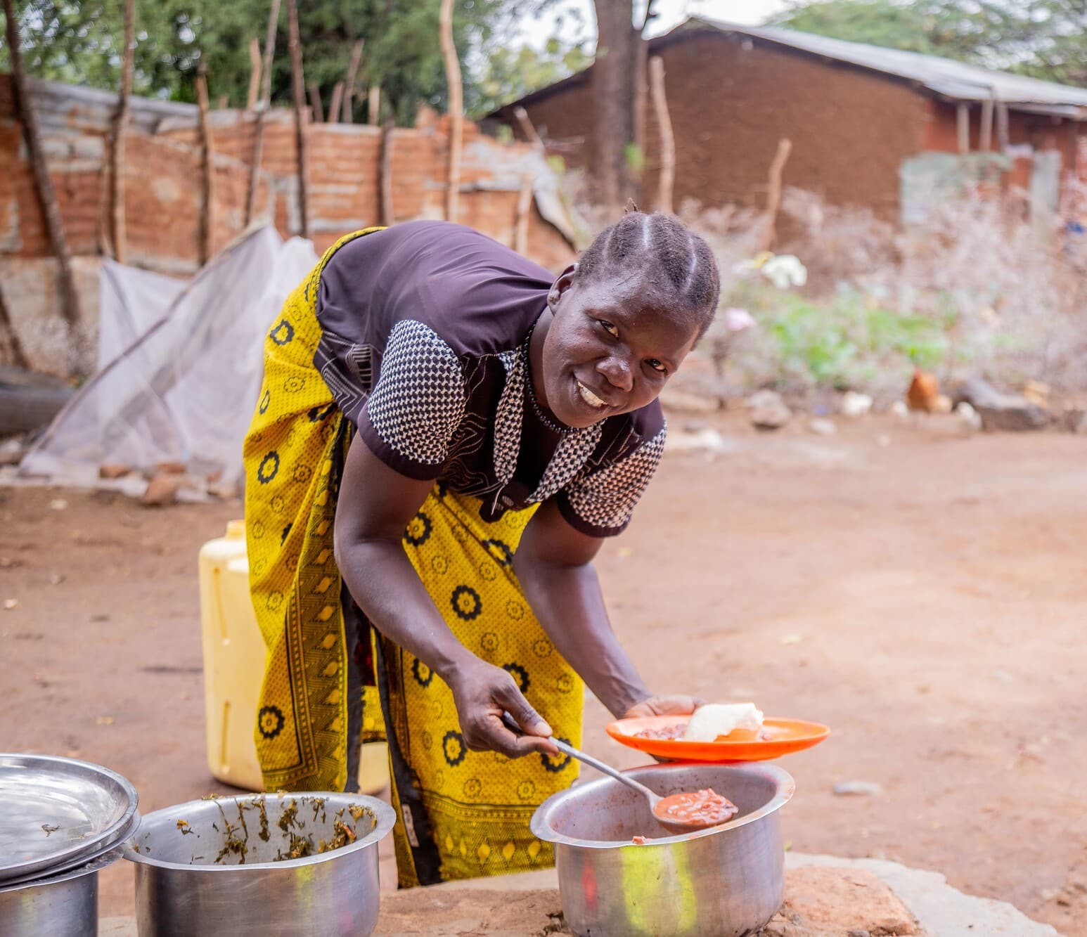 Florence, 42 years old, a member of the Naukoi Riverside Farm Group in Karamoja, Uganda preparing a healthy meal for her children.