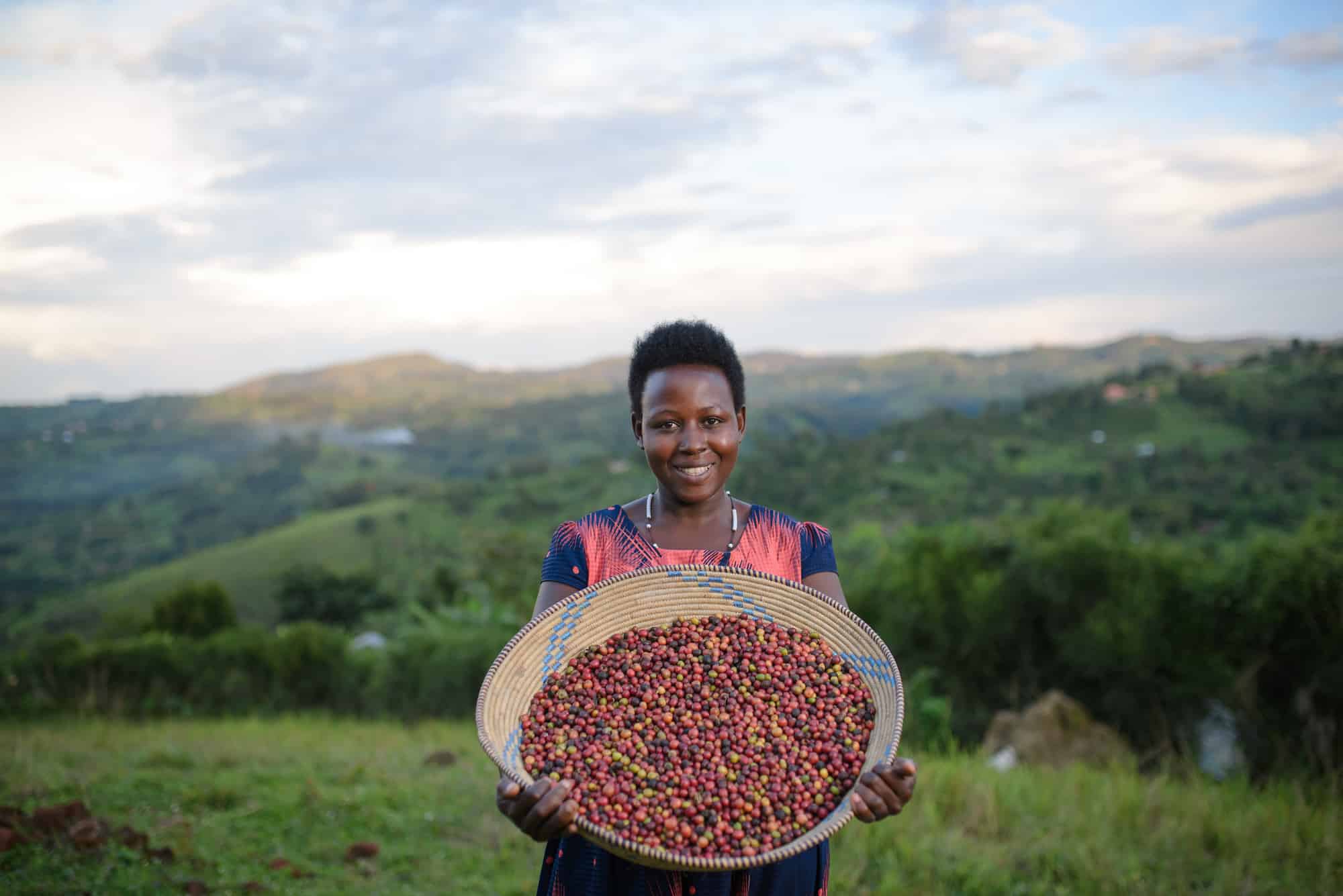 Hildah holding her healthy, ripe coffee beans.