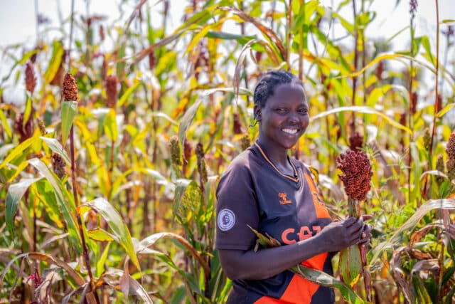 Female farmer, Betty Nakut holding her crop.