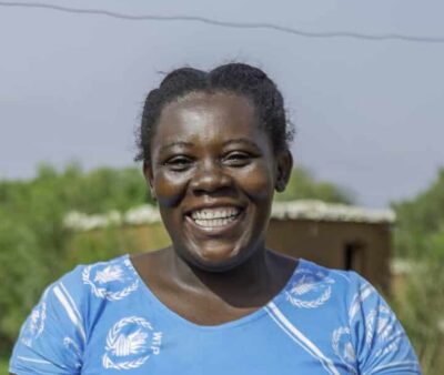 Female farmer Damaris holding her harvested sorghum