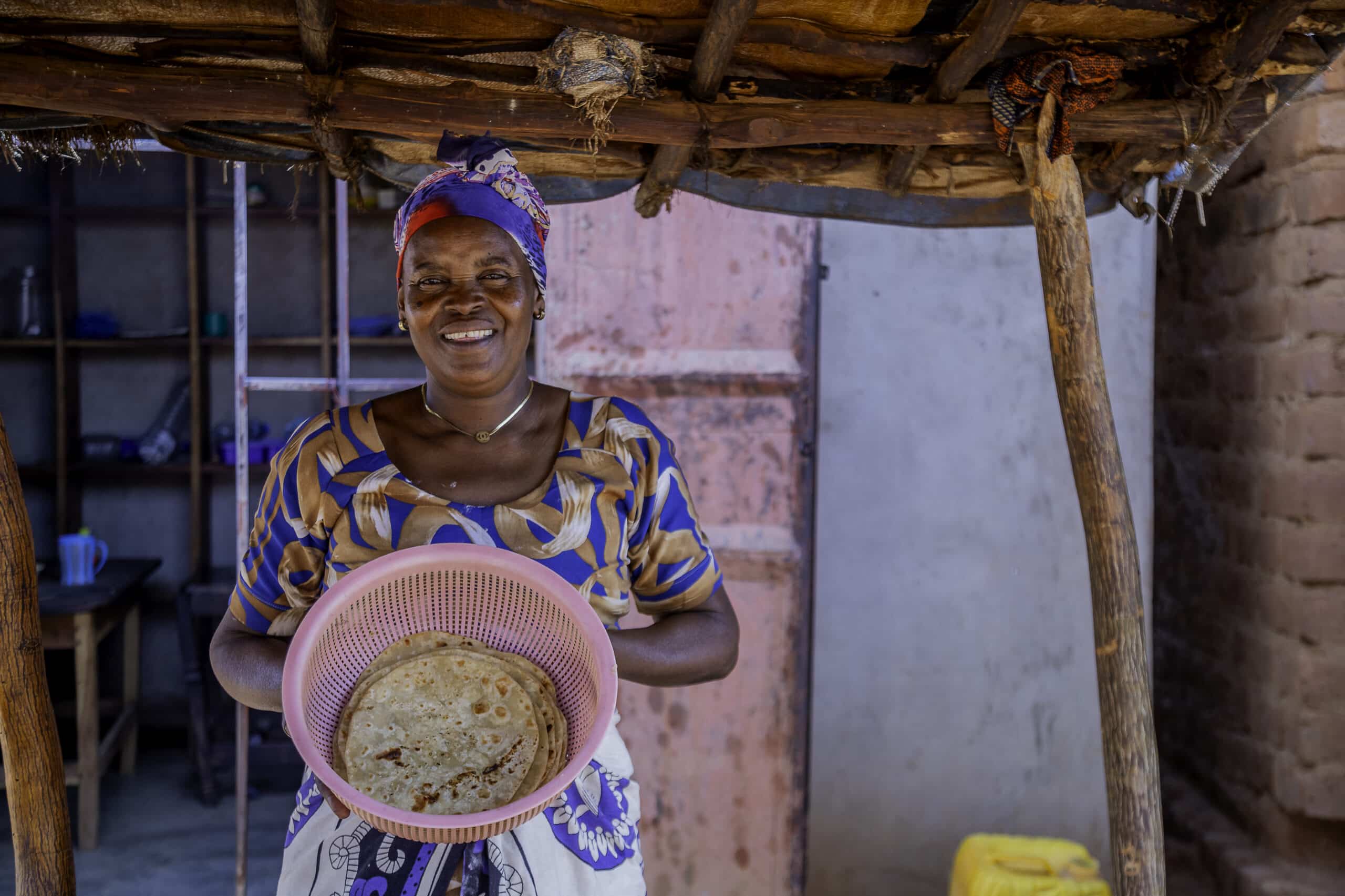 Tanzania farmer and business owner Melina Chikumbi holding a basket of chapatti.