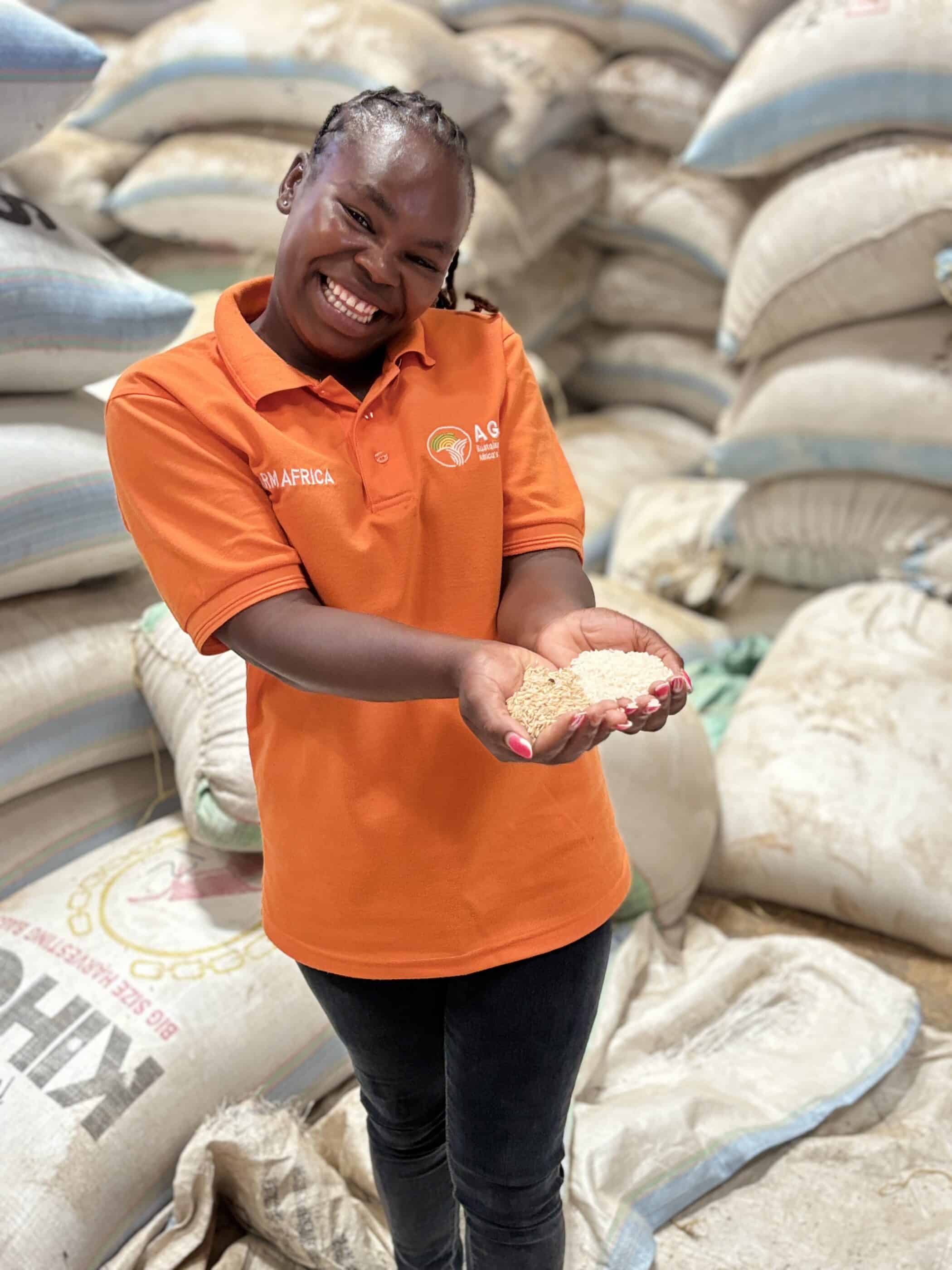Farm Africa employee in Kenya, Felista, holding a handful of grains in a warehouse.