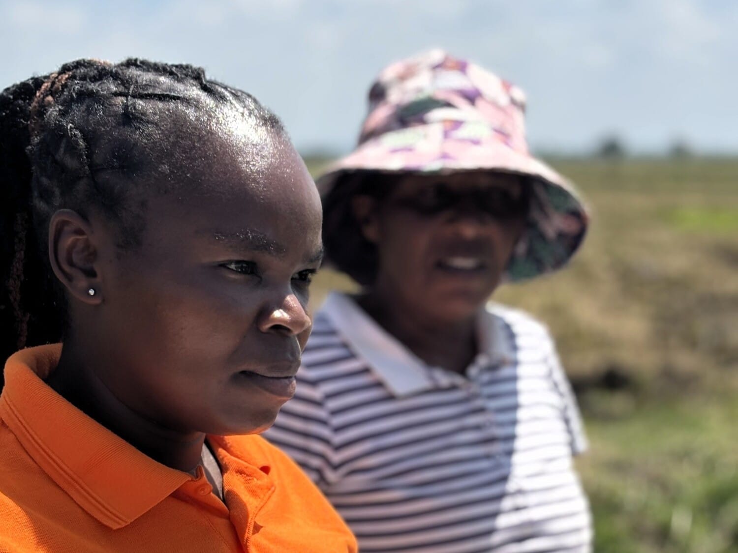 Two female farmers in a field in Kenya.