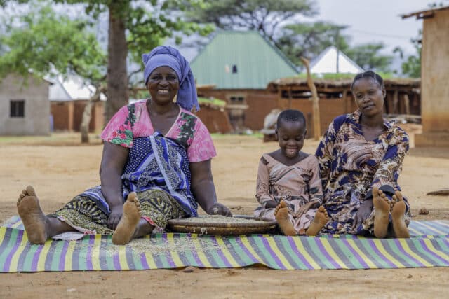 Tanzanian farmer Judith sat with her daughter and granddaughter.