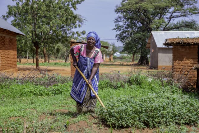 Tanzanian farmer Judith tending to crops in her community kitchen garden.