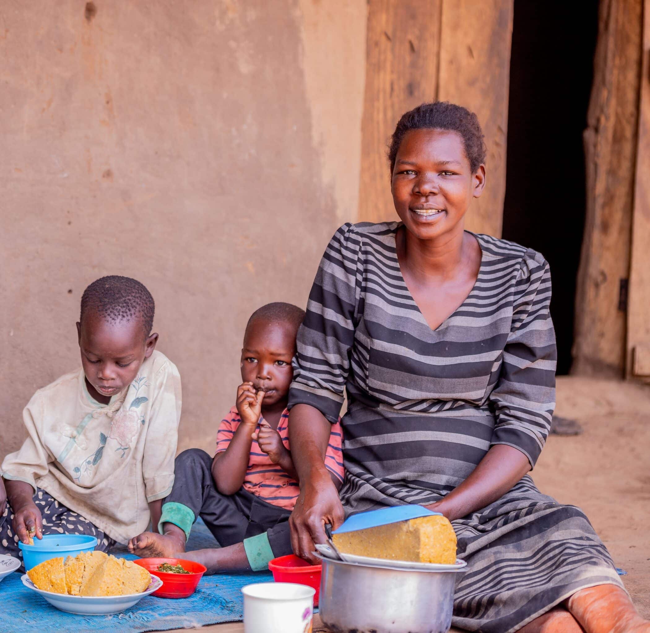 Smallholder farmer Mercy from Karamoja in Uganda feeding her children posho made with vitamin A enhance maize.