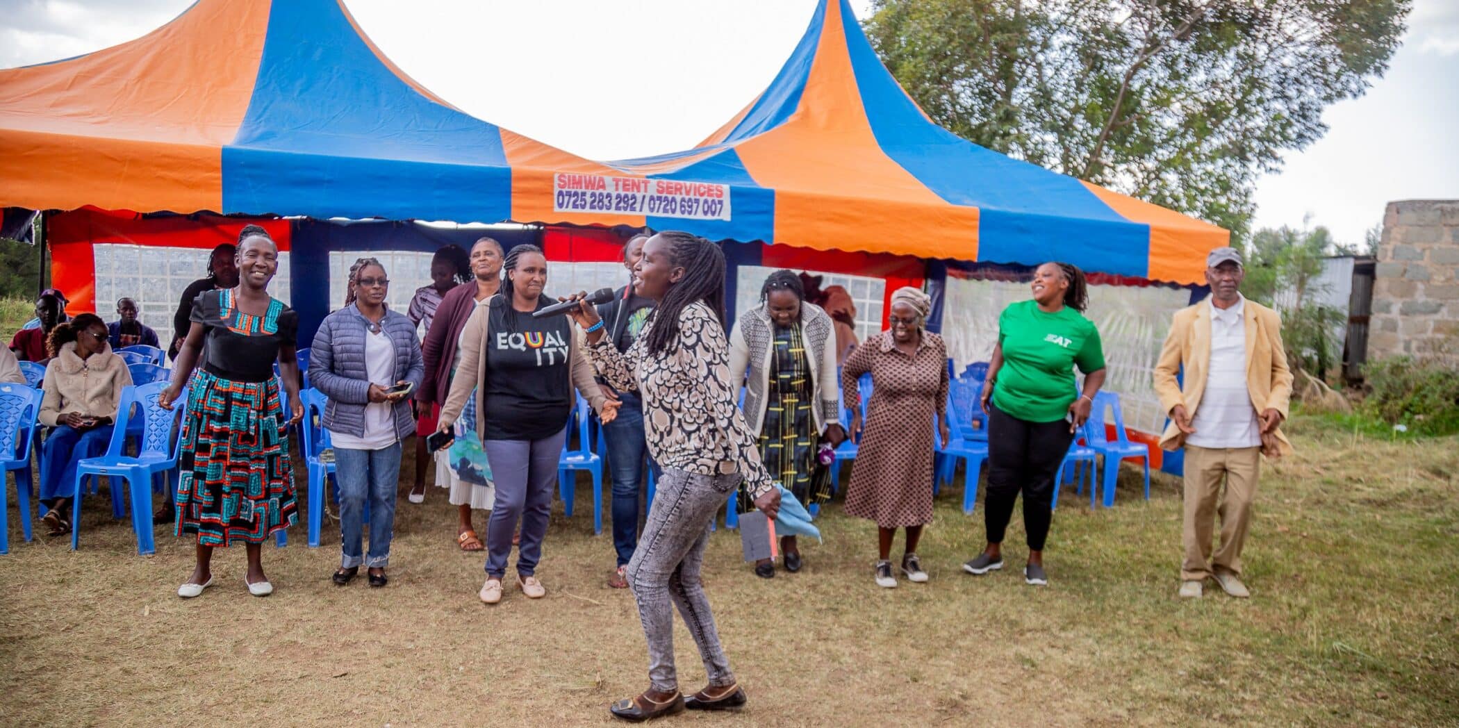 Members of the Kalalu community dancing outside a tent.